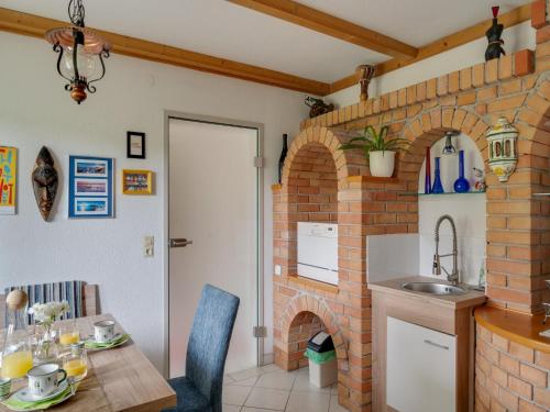 a kitchen with a table and a brick wall at Apartment in Oed-Öhling near Danube River in Mauer bei Amstetten