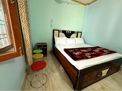 a bedroom with a large bed with a red table at maa kalishila home stay in Ukhimath