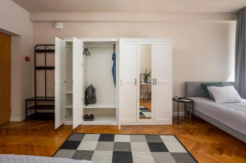 a bedroom with a bed and a white closet at 1800 by Vince Stay - Private Rooms in Town Hall Square in Tartu
