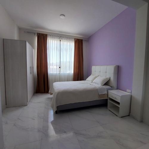 a bedroom with a bed and a purple wall at Amplio departamento en Tarija con terraza y garaje in Tarija