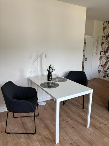a white table and two chairs in a room at Ferienwohnung, Apartment Schwertherz in Wulfsen