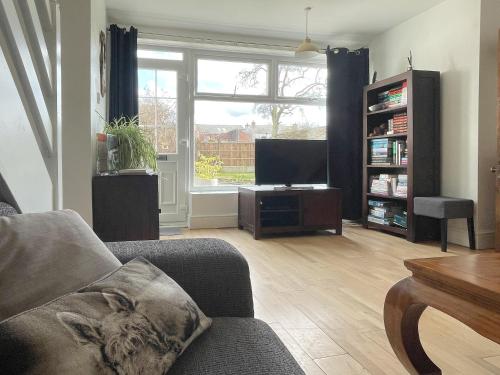 a living room with a couch and a flat screen tv at The Cottage At Stanley Villa in Southport