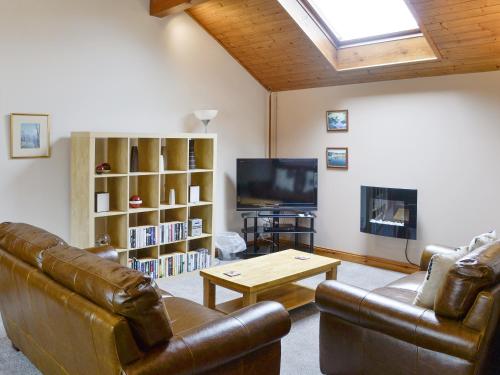 a living room with a couch and a tv at Wickhams View in Keswick