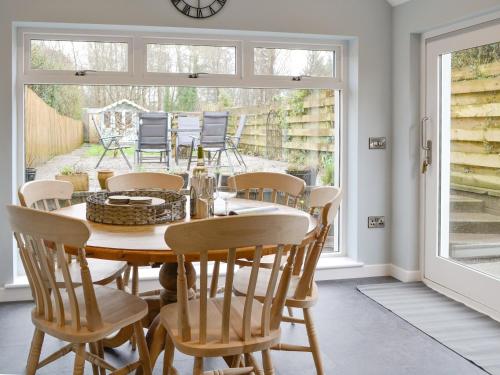 a dining room with a wooden table and chairs at Buckle House in Gatehouse of Fleet