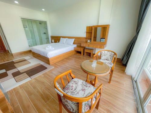 a bedroom with a bed and a table and chairs at Thanh Thanh Station View in Da Lat