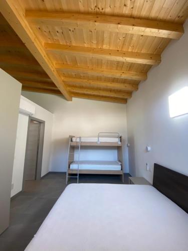 a room with a bed and a wooden ceiling at Chalet Marghe 2 in Rovetta