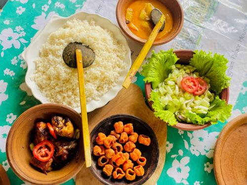 a table with bowls of food with rice and vegetables at Zensigiri Ayurveda Wellness Homestay in Sigiriya