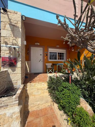 a front porch of a house with a white door at Modern 1-bedroom with BBQ & Roof Garden near Beach in Stalos