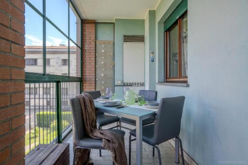a table and chairs on a balcony with a table and a window at 5 minuti da Linate, Deluxe vicino al centro in Milan