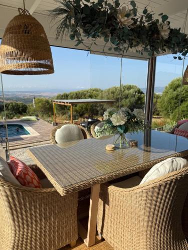 a dining table and chairs with a view of a pool at Wild Mountain Cottage and Pool in Gaucín
