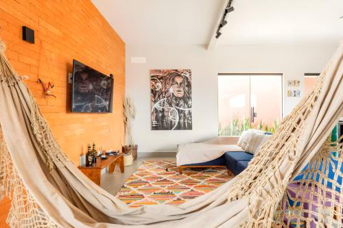 a room with a hammock in a living room at Casa com piscina, vista das montanhas, terraço, quintal in Pirenópolis