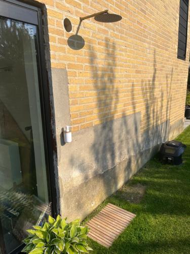 a door with a shadow on a brick wall at Winding B&B Silkeborg in Silkeborg