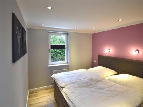 a bedroom with a large bed with a purple wall at Forest-Fringed Comfort in Friedrichshöhe