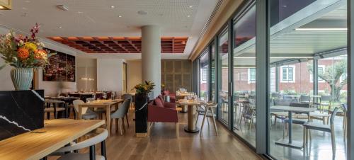 a restaurant with tables and chairs and windows at MACAM Hotel in Lisbon