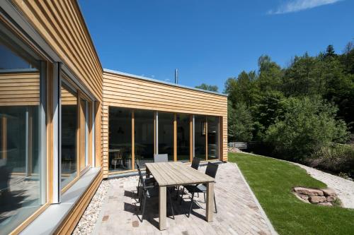 a patio with a wooden table in front of a house at Schwarzwaldstrand Ferienwohnungen in Bad Herrenalb