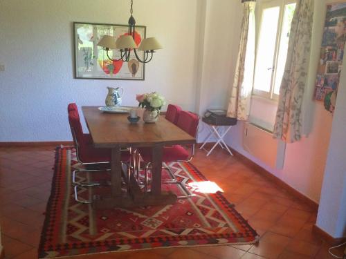 a dining room with a wooden table and red chairs at Verdon Views Pool & Terrace in Montagnac