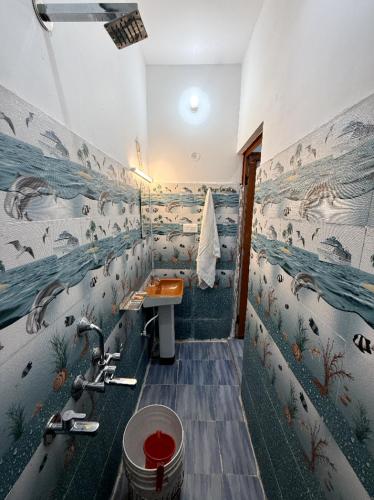 a bathroom with a sink and a mural of animals at maa kalishila home stay in Ukhimath