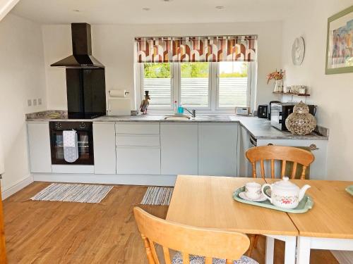 a kitchen with a wooden table and a wooden table sidx sidx sidx at Cartwheel Cottage in Hayton