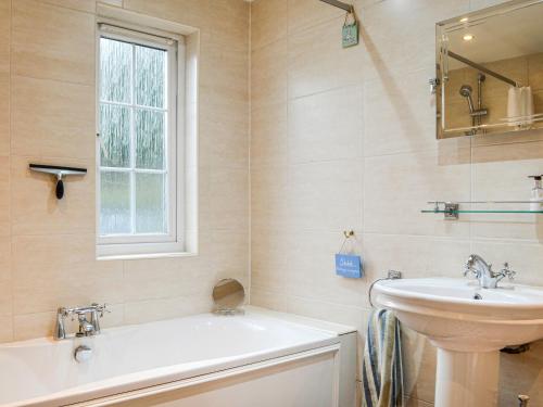 a bathroom with a sink and a bath tub and a sink at The Smithy in New Galloway