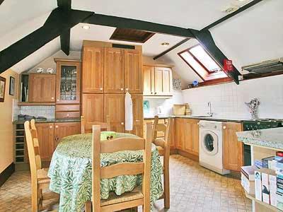a kitchen with a table and a kitchen with a stove at Dove Cottage in Minehead