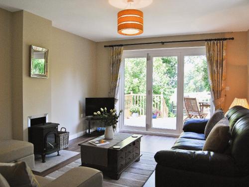 a living room with a couch and a tv at Bramble Cottage in Wimborne Minster