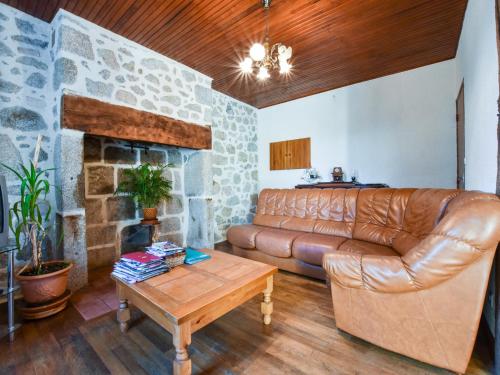 a living room with a leather couch and a fireplace at Sénezergues Garden Hideaway in Cassaniouze