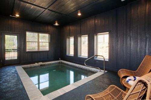 ピジョン・フォージにあるMtn Luxury Prime - Indoor Pool & Arcade Near Townの椅子と窓のある客室内のスイミングプールを利用できます。