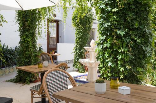 a patio with wooden tables and chairs and ivy at Hotel La Marsellesa in Pego
