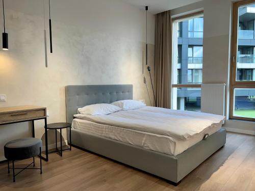 a bedroom with a bed and a desk and a window at FORUM apart in Lviv