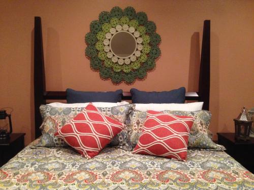 a bedroom with a bed with pillows and a mirror at Maple Creek Bed&Breakfast in Tomball