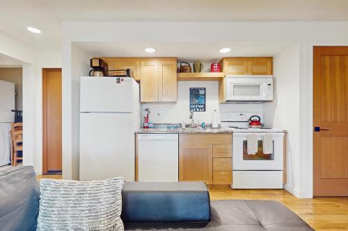a kitchen with a white refrigerator and wooden cabinets at Rose's Reach - Rosario in Eastsound
