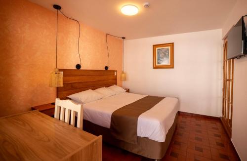 a hotel room with a bed and a television at San Sebastian Hotel Boutique in Huaraz
