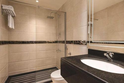 a bathroom with a sink and a toilet and a mirror at Dancenter Red Sea Fountain Alhamra Vivid Plaza Hotel in Jeddah