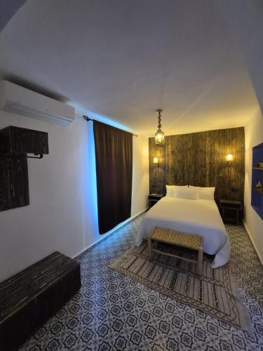 a bedroom with a white bed and a rug at CASA TROUSSI in Chefchaouene