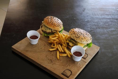 a tray with a hamburger and french fries and ketchup at Hotel Baez Paraiso in Paraíso