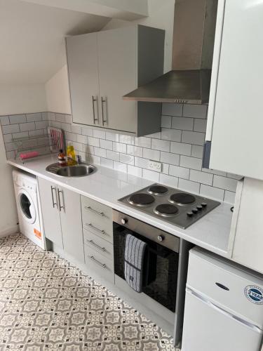 a small kitchen with a stove and a sink at The Hive at 205 in Manchester