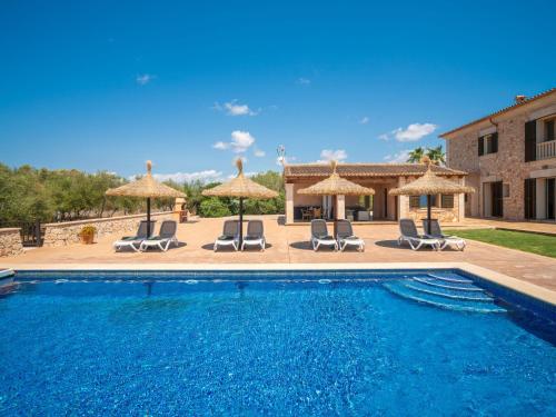 una piscina con sillas y sombrillas y una casa en Holiday Home Eva by Interhome, en Ses Salines