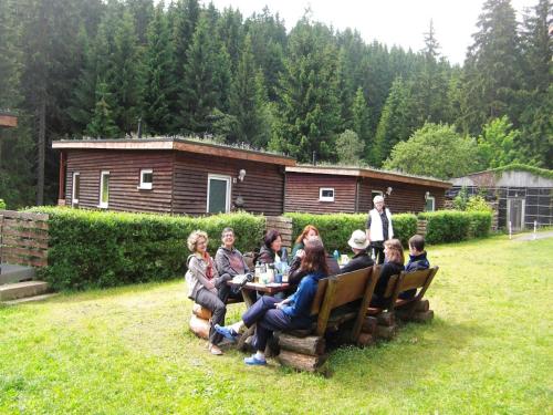 a group of people sitting at a table in a yard at Holiday Home with Garden in Altenfeld