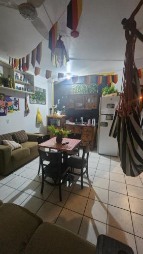 a kitchen and living room with a table and a refrigerator at Hostel Lumaria 1 in Blumenau