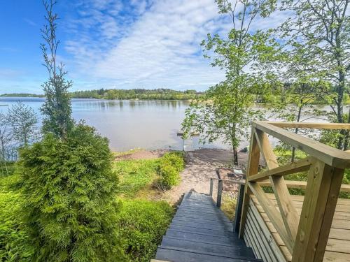 a wooden staircase leading to a lake with a view at Holiday Home Punatulkku by Interhome in Hirsjärvi