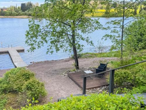a wooden bench sitting next to a lake at Holiday Home Punatulkku by Interhome in Hirsjärvi