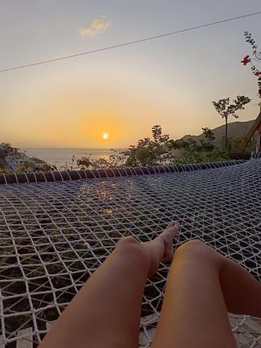 a woman laying on a hammock watching the sunset at Tayrona Colors Hostel in Taganga