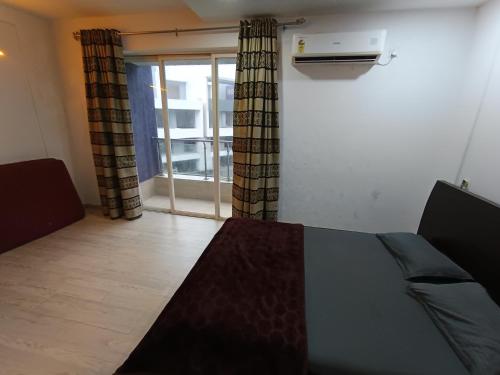 a room with a bed and a window with a heater at Sky line villa, Lonavla in Lonavala