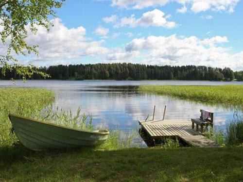 a boat sitting next to a dock on a lake at Holiday Home Alppimaja by Interhome in Pätiälä