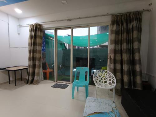 a room with a blue chair and a window at Sky line villa, Lonavla in Lonavala
