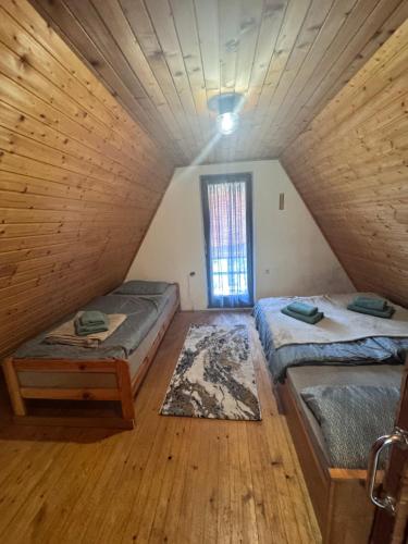 a attic room with two beds and a window at Chalet SS Pohorje in Pohorje