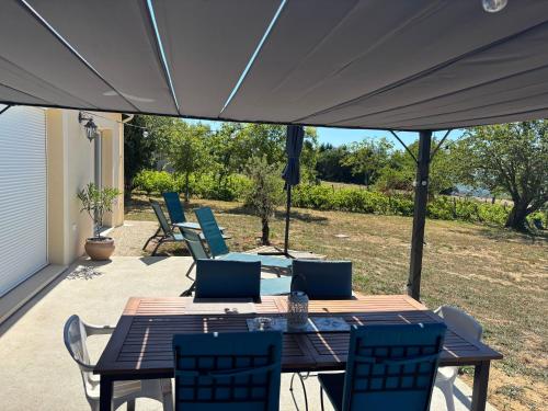 a patio with a table and chairs under a tent at Maison La Vigne in Marcillac-Saint-Quentin