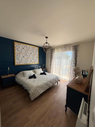 a bedroom with a bed with two black shoes on it at Maison La Vigne in Marcillac-Saint-Quentin