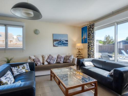 Una sala de estar con sofás y una mesa. en Villa Nael by Interhome, en Vendays-Montalivet