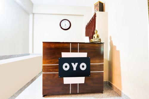 a sign on a dresser in a room with a clock at Hotel O Castle Inn Kondapur in Hyderabad